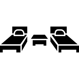deux lits simples et une petite table au milieu des meubles de la chambre Icône