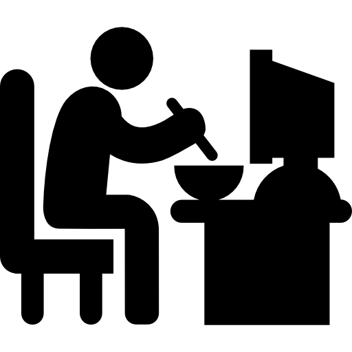 Человек сидит за своим рабочим столом, обедает  иконка